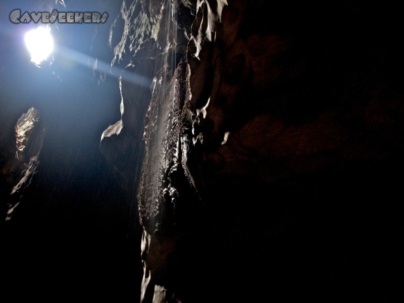 Dark Cave: Ungewöhlich viele Löcher in der Decke - und damit Zugänge zum Loch. Im Vordergrund kann man unter erheblicher Unschärfe einen durchaus aktiven Wasserfall erkennen. Nicht zu sehen hingegen sind die Fledermausmassen, die den ihnen eigenen Lärm verursachen. Dieses Erlebnis führt dem fränkischen Fledermausschützer drastisch vor Augen, wie wichtig Fledermausschutz - global betrachtet - ist. Die Biomasse der Fledermäuse alleine in diesem Loch dürfte in etwa der der akkumulierten Biomasse aller Fledermäuse in Deutschland von 1900 bis heute entsprechen.