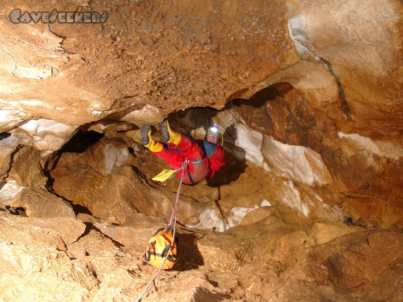 Große Spielberghöhle: Grinse-Fitzner, mit dem Sack voran, hängend an der dritten Abseilstelle.