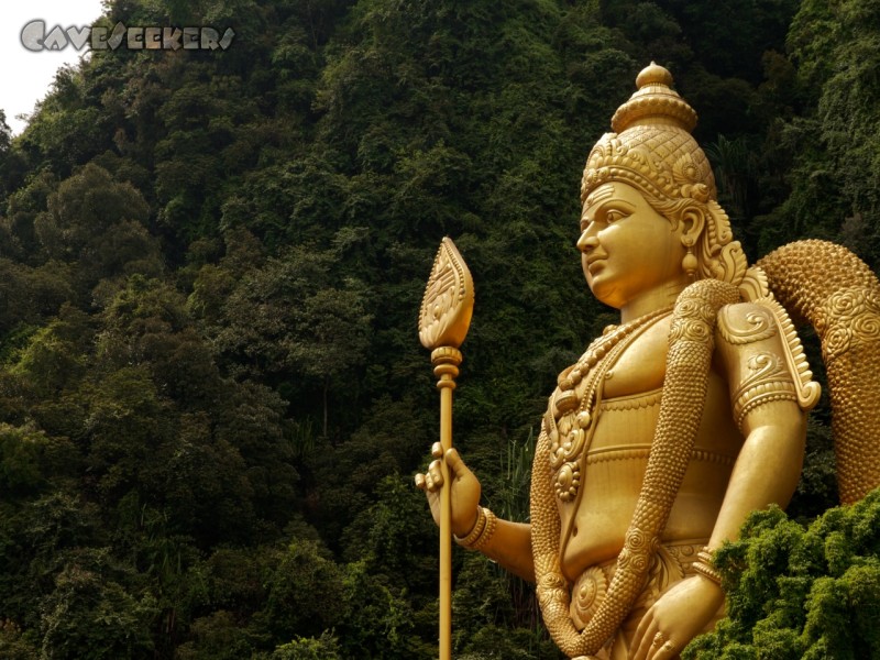 Batu Caves - Riesiger, 40 Meter hoher Höhleneingangskaspar in Gold. Steht am Fuße der Treppe zum Loch.