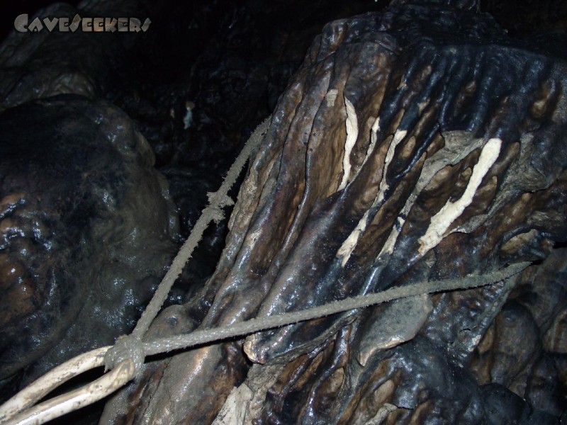 Dürrloch: Die Befestigung des Kabels mittels eines eher unsolide wirkenden Seils, zerstörter Stalagmit.