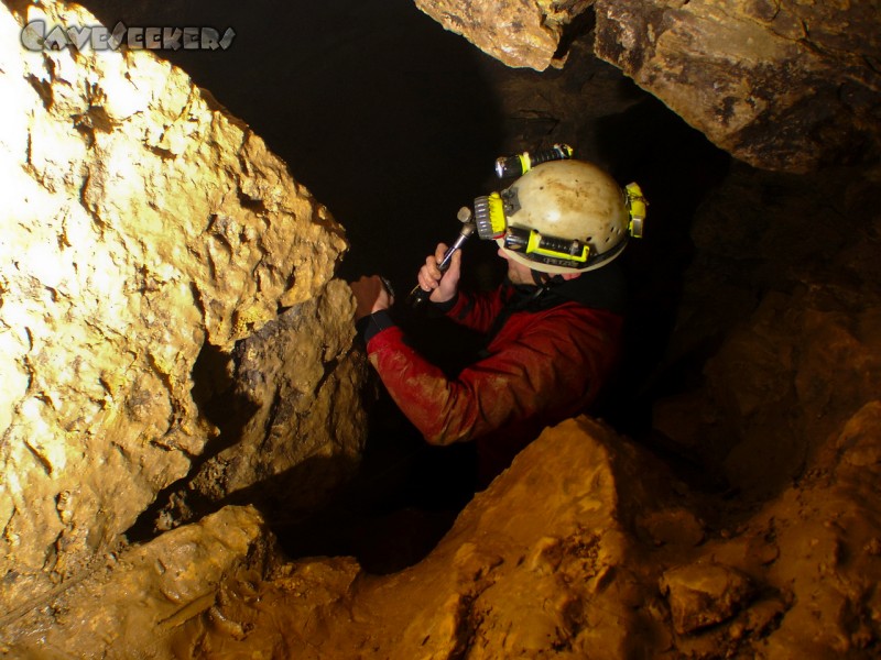 Heinzengrabenhöhle: Herr Kreil beim vorschriftsmäßigen setzen einer Lasche zur professionellen Befestigung der Führungsleine durch den Siphon.