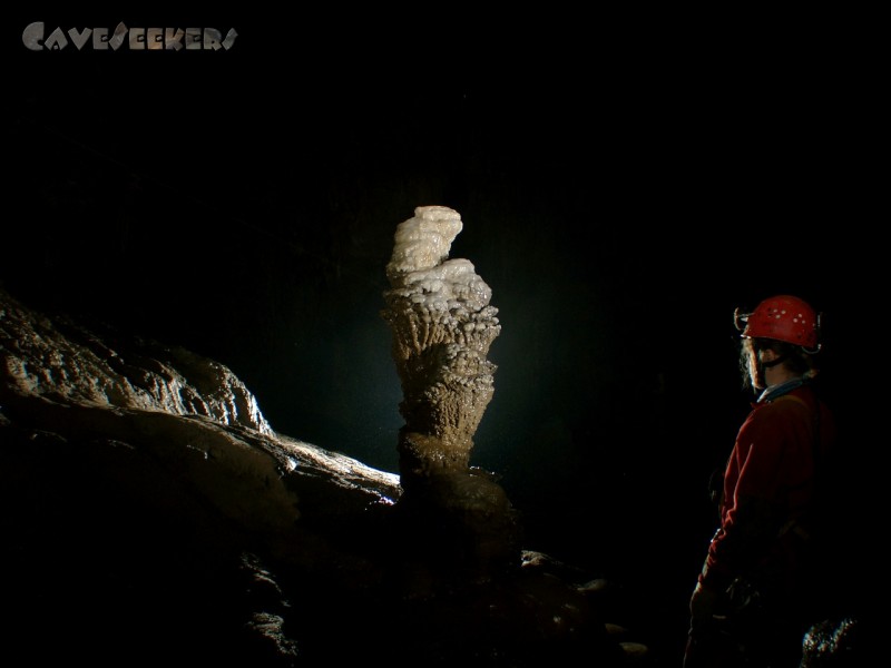 Kacna Jama: Stalagmit vor Schwarz. Mit Frau.